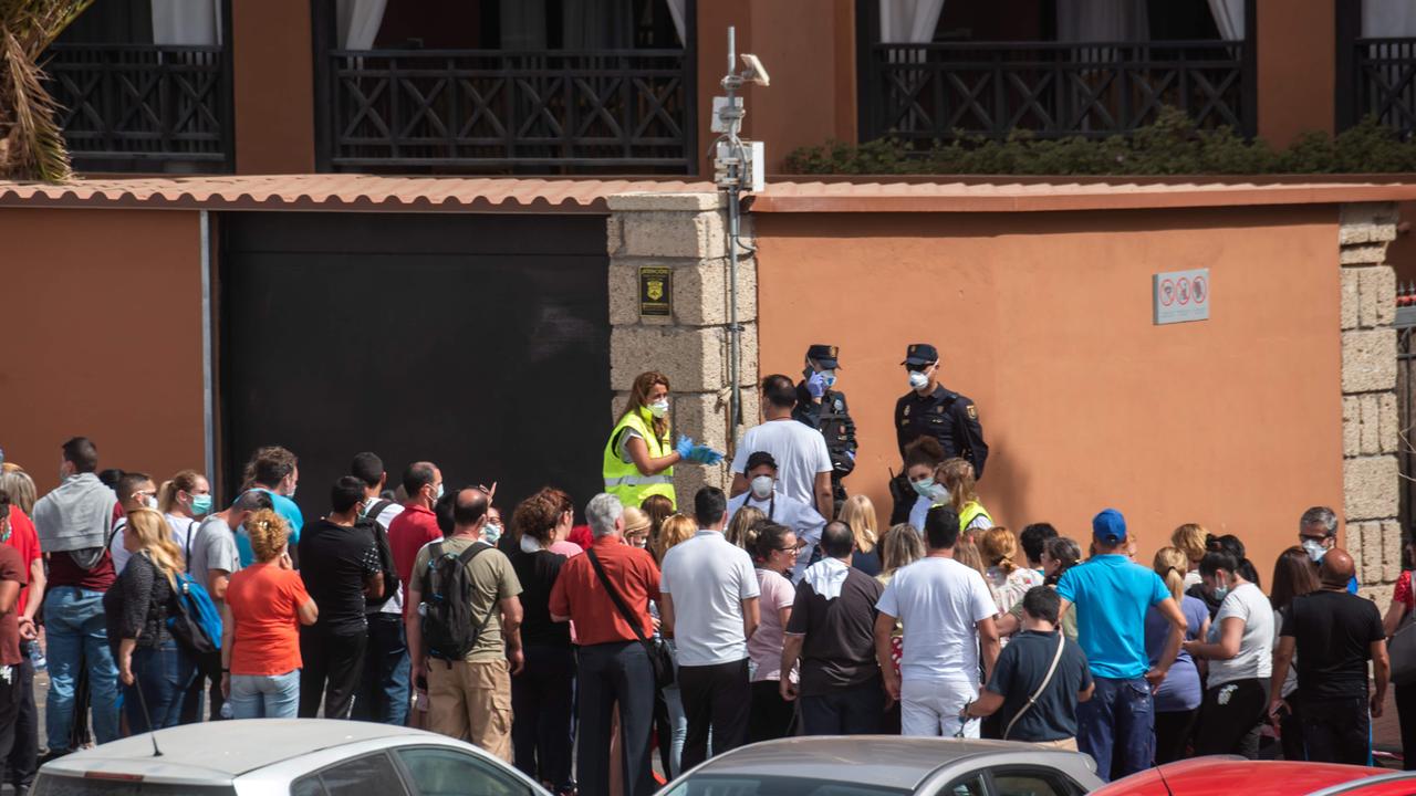 A psychologist talks to a group of workers outside the H10 Costa Adeje Palace Hotel in La Caleta on February 25, 2020, where hundreds of people were confined after an Italian tourist was hospitalised with a suspected case of coronavirus. Picture: Desiree Martin/AFP