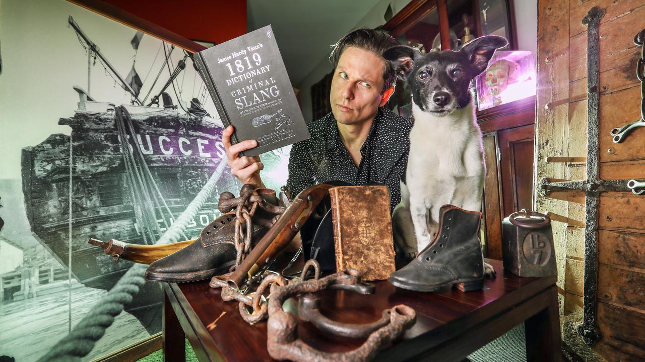 Simon Barnard reading his new book about convict slang to his dog Tuco, surrounded by convict artefacts. Picture: Alex Coppel