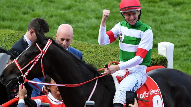 Jockey Damian Lane (centre) reacts after riding Lys Gracieux to Victory in race 9, the Ladbrokes Cox Plate during Cox Plate Day at Moonee Valley Racecourse, Melbourne, Saturday, October 26, 2019. (AAP Image/James Ross) NO ARCHIVING