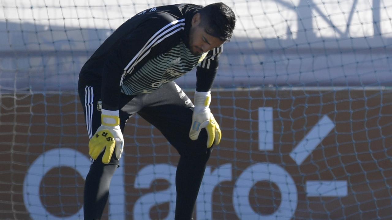 Argentina's goalkeeper Sergio Romero stretches out his injured knee during a training session in Buenos Aires.