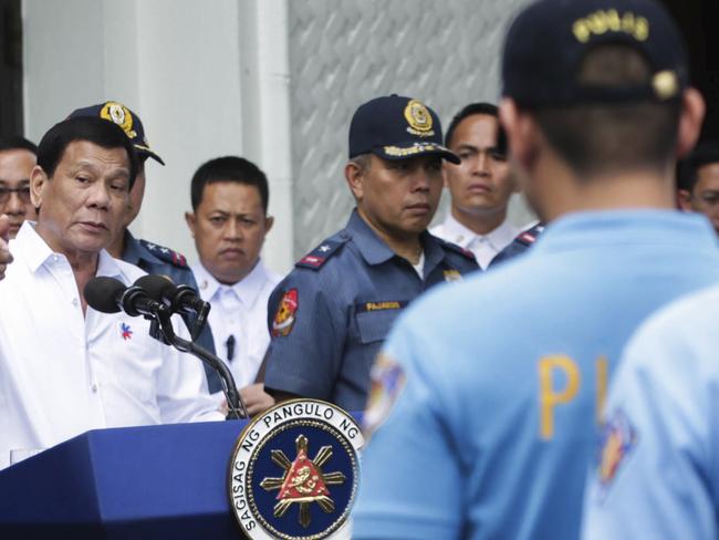In this photo provided by the Presidential Photographers Division, Malacanang Palace, Philippine President Rodrigo Duterte, left, berates erring policemen during an audience at the Presidential Palace grounds in Manila, Philippines, Tuesday, Feb. 9, 2017. Duterte angrily berated more than 200 allegedly erring policemen and said he would send them to a southern island to fight extremists dreaded for their beheadings. Duterte's expletive-filled outburst against the officers at the palace was his latest tirade against a police force that he has called 