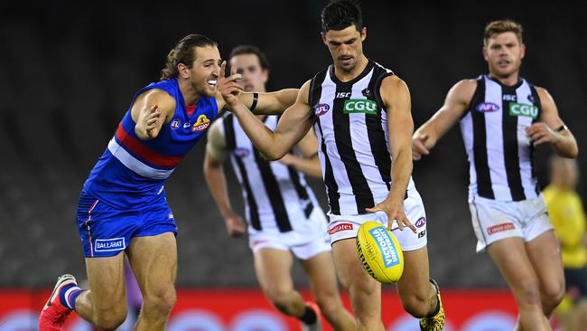 Marcus Bontempelli tries to land a tackle on Scott Pendlebury during the round 1 AFL match between the Western Bulldogs and Collingwood on March 20. Picture: GETTY