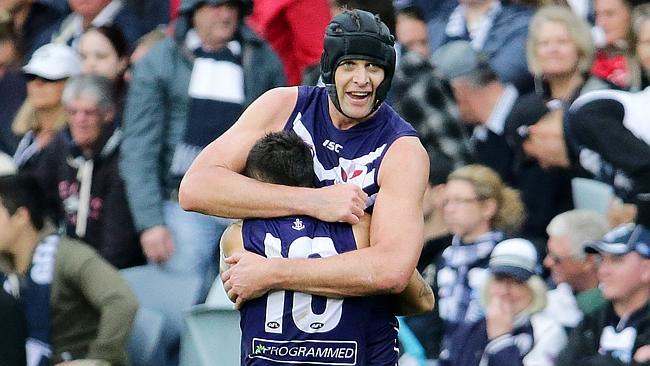 Aaron Sandilands shares a celebratory hug with regular-sized human Michael Walters. Photo: George Salpigtidis