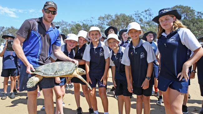 Students from Sandy Beach Public School watching three turtles being released at Sandy Beach.