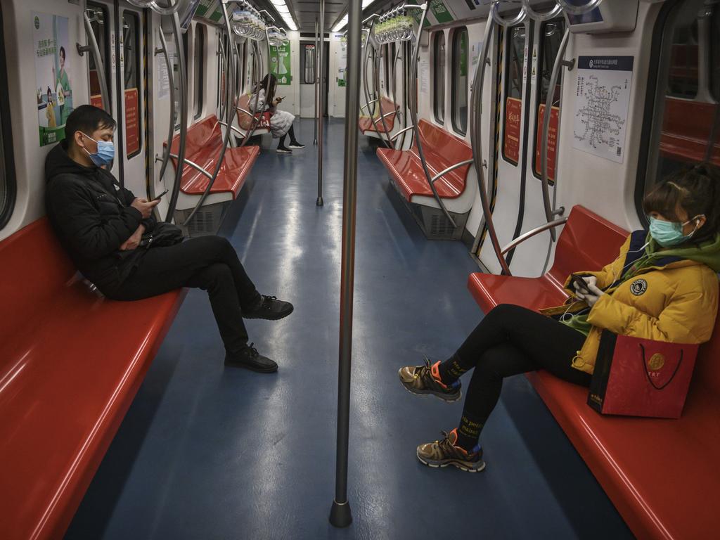 People wear protective masks as they ride on a nearly empty train during the evening rush last night in Beijing. Picture: Kevin Frayer/Getty Images