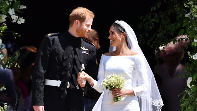 Prince Harry and his wife Meghan emerge from St George’s Chapel. Picture: AFP Photo/Pool and AFP Photo/Ben Stansall