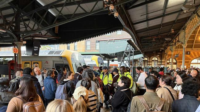 Commuters are seen waiting for information on Tuesday afternoon