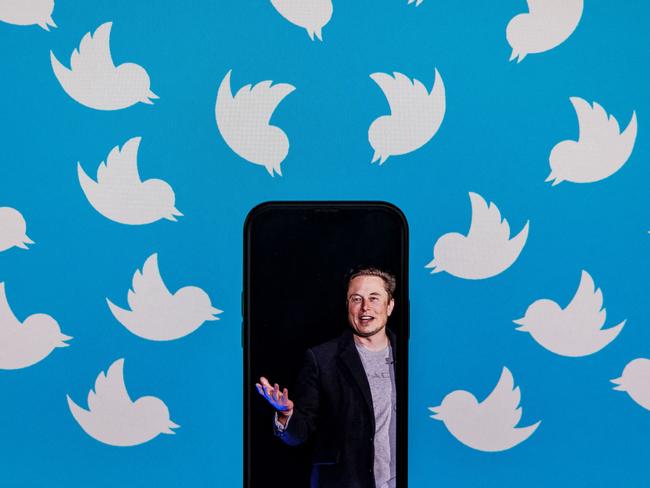 (FILES) This file photo illustration taken on August 05, 2022, shows a cellphone displaying a photo of Elon Musk placed on a computer monitor filled with Twitter logos in Washington, DC. - Twitter suspended December 15, 2022, the accounts of more than a half-dozen journalists who had been writing about the company and its new owner Elon Musk. Some of the journalists had been tweeting about Twitter shutting down an @ElonJet account that tracked flights of the billionaire's private jet and about versions of that account hosted at other social networks. (Photo by SAMUEL CORUM / AFP)