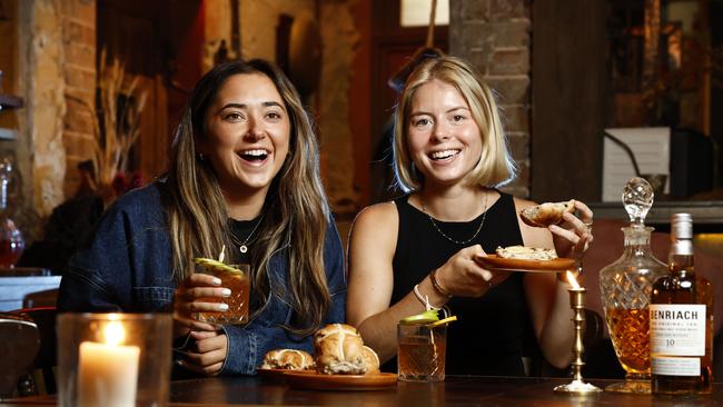 Abby Legg and Siri Place, enjoying scotch cross buns, which are infused with whisky, The Grounds in Alexandria. Picture: Richard Dobson