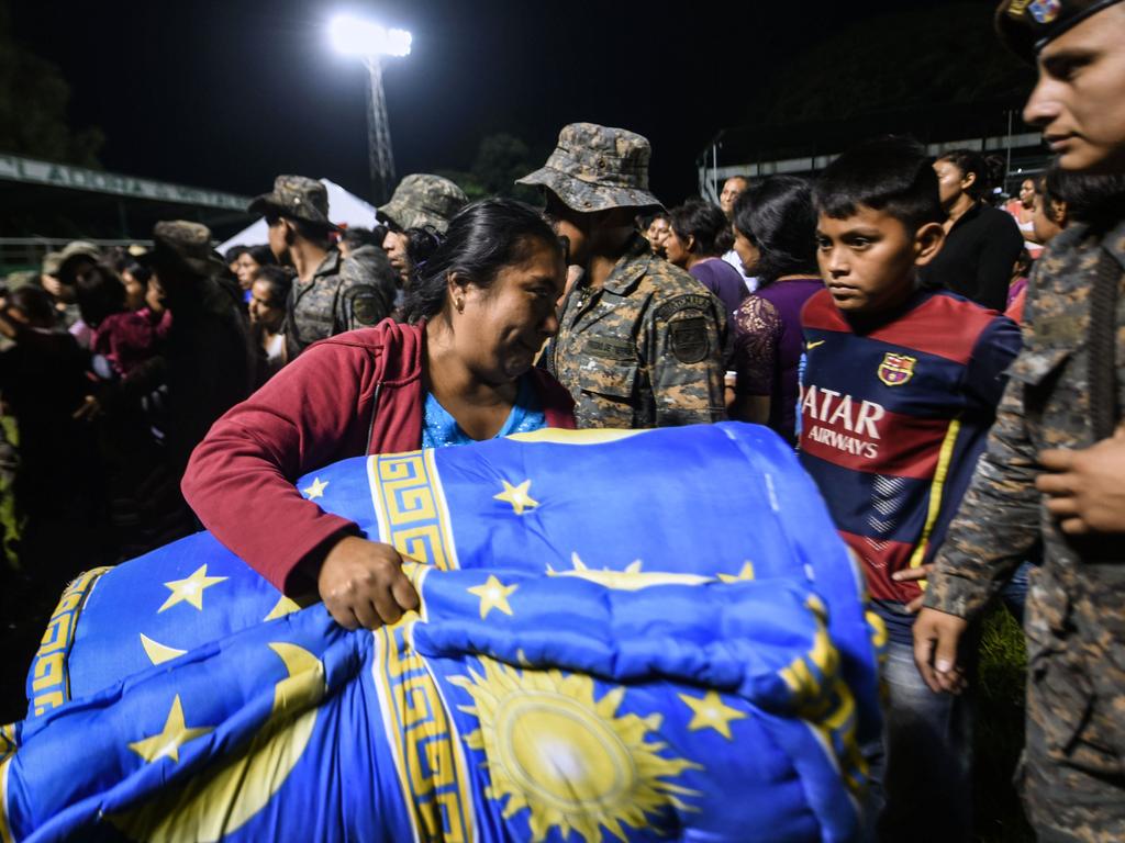 Residents of several communities nearby the erupting Fuego volcano, arrive at a temporary shelter. Picture: Johan Ordonez/AFP