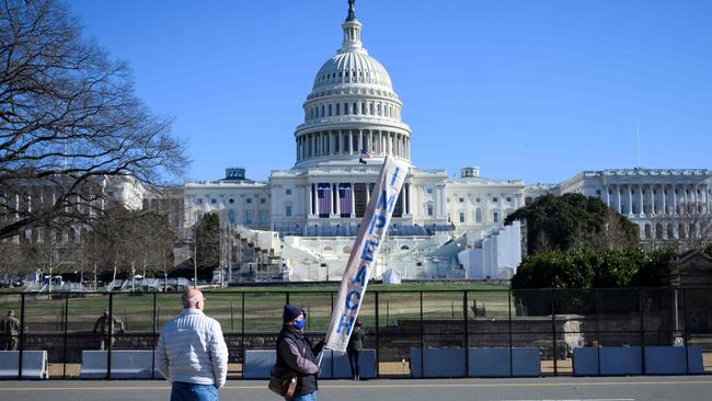 A protester carries a sign calling for Congress to impeach Donald Trump, near the US Capitol. Picture: AFP.