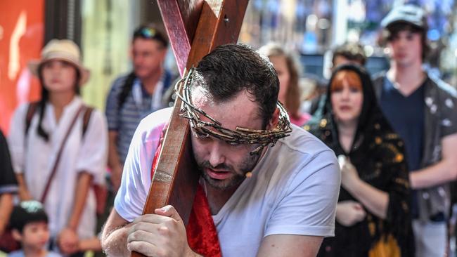 Jesus played by actor Alec Green carries the cross during a re-enactment in Sydney on Good Friday. Picture: AAP