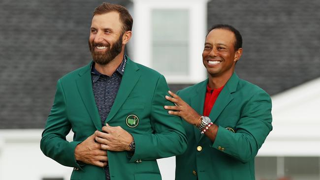 American Dustin Johnson has the green jacket placed on him by last year’s tournament champion Tiger Woods after winning the 84th Masters at Augusta National. Picture: Patrick Smith/Getty Images