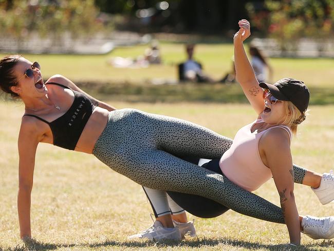 L-R Housemates Caitlin O'Neill and Thalia Price exercise during a picnic at New Farm park. Picture: Lyndon Mechielsen.