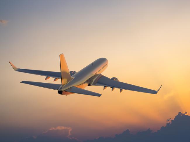 Passanger airplane flying above clouds in evening.