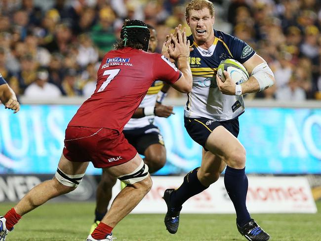 Brumbies flanker David Pocock fends off Reds rival Liam Gill.