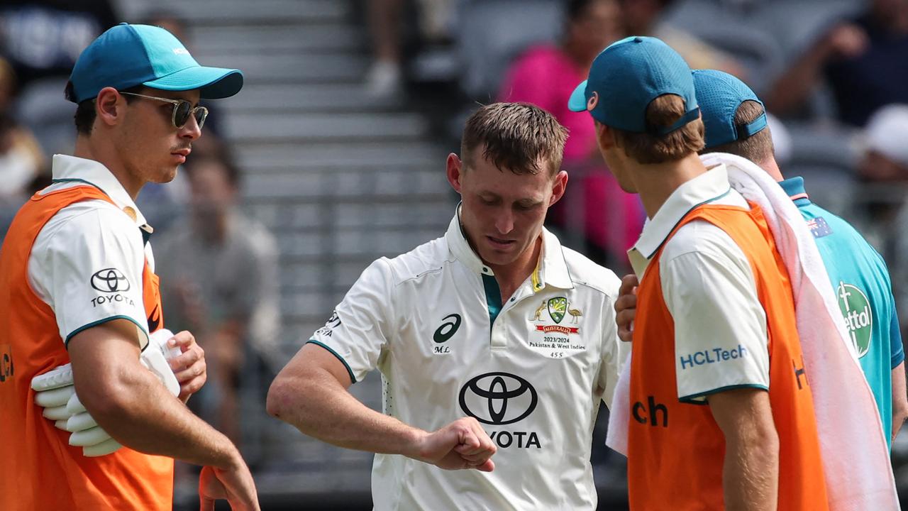 Australia's Marnus Labuschagne (C) inspects his injured finger during day three. Picture: AFP