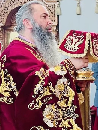 Father John Christodoulos with the communion chalice at St Andrew. Parish Picture: Supplied