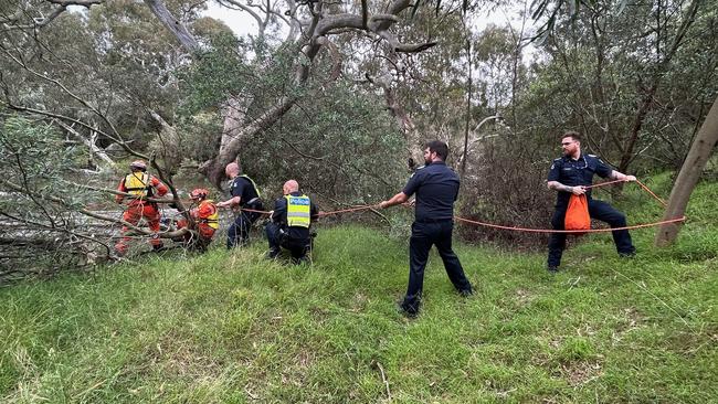 Emergency crews helping Madi and her dog Minka after they were stranded in the Werribee River.