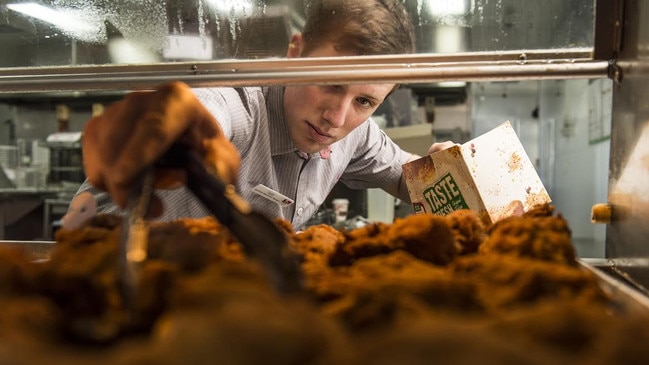 A fast food service industry worker serves Kentucky Fried Chicken or KFC.