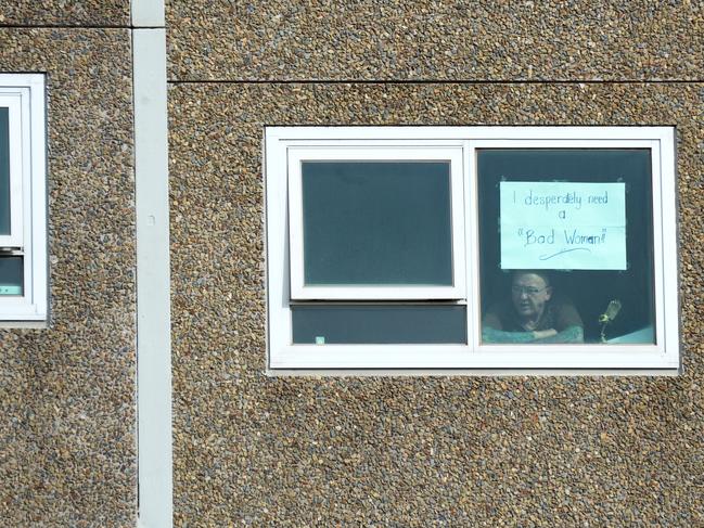 A resident looks out in hope from his window from a locked-down public housing block in Melbourne.