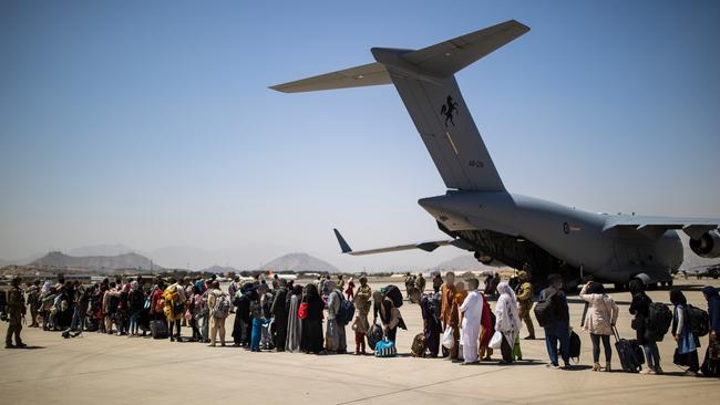 Afghan families line up behind the RAAF C-17A Globemaster before departing Hamid Karzai International Airport. Picture: ADF