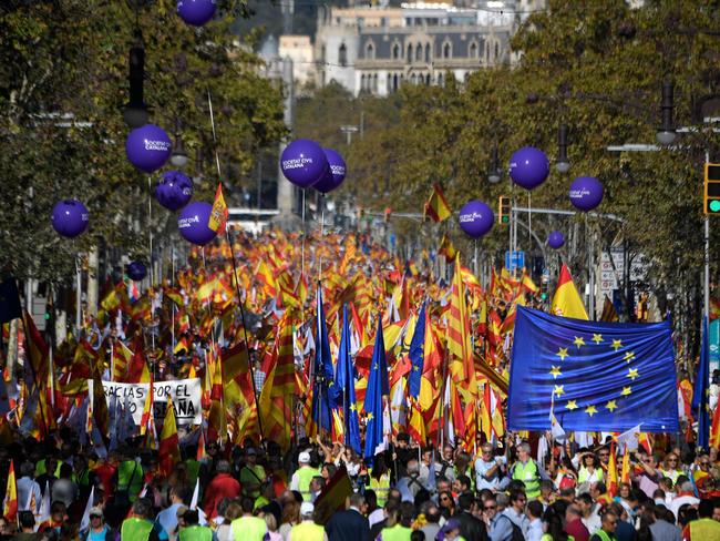 People hold Spanish and EU flags during a pro-unity demonstration in Barcelona on October 29. Picture: Lluis Gene/AFP