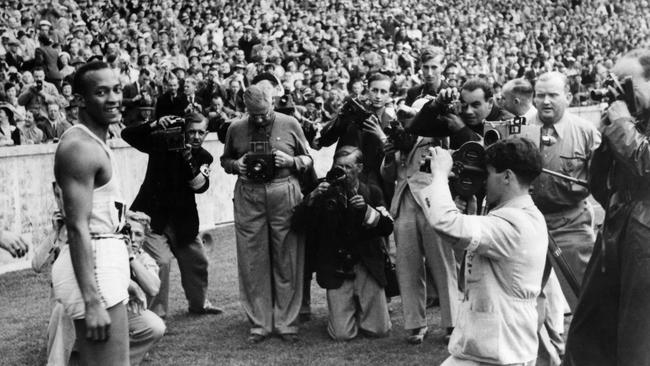 Jesse Owens surrounded by press photographers after winning the 100m sprint at the Berlin games in 1936.