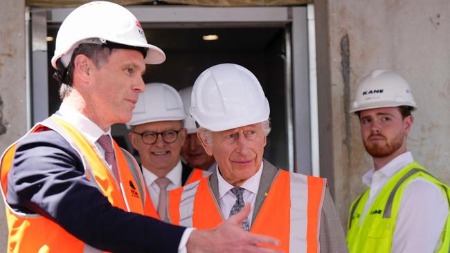 Charles is assisted by NSW Premier Chris Minns (L) while Prime Minister Anthony Albanese walks behind as he visits the Homes NSW Cowper Street development in Sydney on October 22. Picture: Mark Baker / POOL / AFP