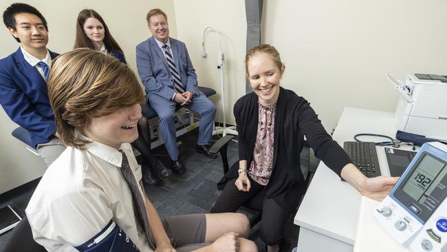 Billy Smith gets his blood pressure checked by GP Natasha Duncan as classmates Eden Dot, Lily Crittenden and principal Ross Bailey look on.