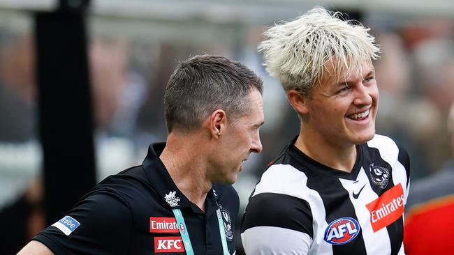 Craig McRae speaks with Jack Ginnivan during a game.