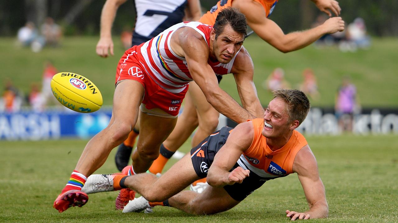 Jackson Hately fires out a handpass in front of Sydney’s Josh Kennedy. Picture: Dan Himbrechts/AAP