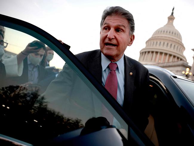 (FILES) In this file photo taken on December 14, 2021: Sen. Joe Manchin (D-WV) is followed to his car by reporters after participating in a vote at the US Capitol Building in Washington, DC. - US Senator Joe Manchin, a moderate Democrat whose support is crucial to passing a massive social spending bill, said on December 19, 2021 that he is a "no" on the legislation seen as critical to President Joe Biden's legacy. "I can't vote for it and I cannot vote to continue with this piece of legislation. I just can't," Manchin said on Fox News Sunday. (Photo by Anna Moneymaker / GETTY IMAGES NORTH AMERICA / AFP)