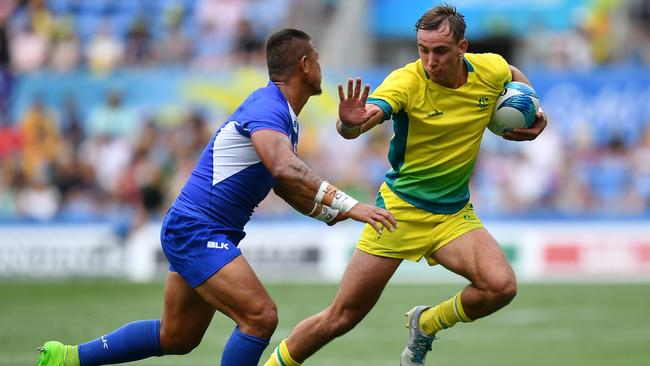 GOLD COAST, AUSTRALIA - APRIL 14: John Porch of Australia makes a break past Alatasi Tupou of Samoa during Rugby Sevens Men's Pool B match between Australia and Samoa on day 10 of the Gold Coast 2018 Commonwealth Games at Robina Stadium on April 14, 2018 on the Gold Coast, Australia. (Photo by Dan Mullan/Getty Images)