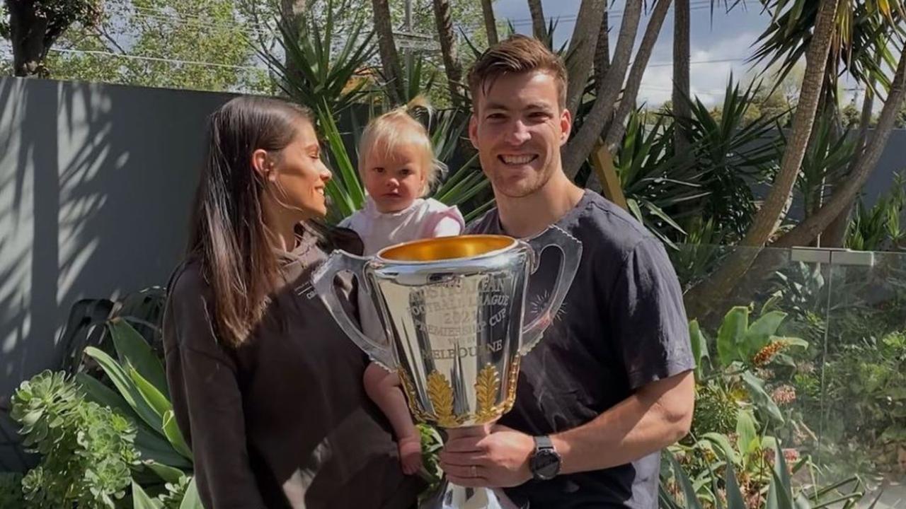 Melbourne Demons player Jack Viney with his wife Charlotte, daughter Mia and dog Sebastian with the Premiership Cup. Picture: Instagram