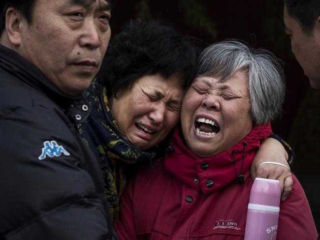 Chinese relatives of a missing passenger weep outside the main gate of the Lama Temple in Beijing. Picture: Getty