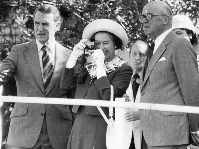 <b>1977 – South Australia</b> On a visit to the Lindsay Park stud in Angaston, with racehorse owner-trainer Colin Hayes, left, the Queen took out her gold Rollei pocket camera to photograph the horse Without Fear. The Queen is known for her keen interest in her own stable of racehorses and in her Silver Jubilee year enjoyed success at two classic British races, The Oaks and the St Leger, with her horse Dunfermline.