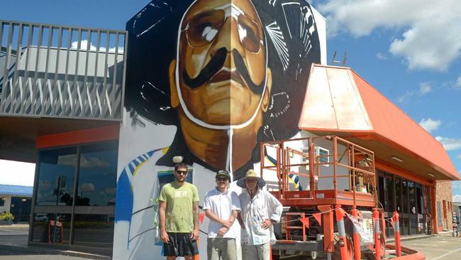 Out There Co. artists Jon Watson, Luke and Bill Gannon create the Harry MiMi mural on Gladstone Road. Picture: Jann Houley