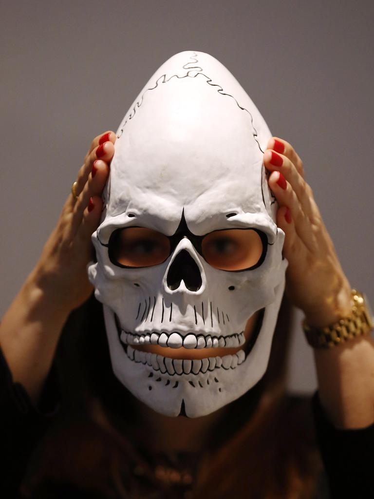 A member of staff poses with the mask from James Bond’s Day of the Dead Costume, worn by Daniel Craig in Spectre, during a photocall at Christie’s auction house on February 15, 2016 in London, England. Forming part of the ‘James Bond Spectre - The Auction’ sale on 18th February it is expected to fetch between 12,000 - 18,000 GBP. (Photo by Carl Court/Getty Images)