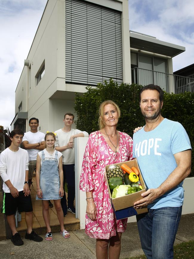 L to R: Edyn Harapin -15, Nathan Harapin -21, Kaiya Harapin -12, Tyler Harapin -18, Diane Harapin and Paul Harapin in front of their home with a box of produce. From self-imposed isolation in their home, Diane and her family are organising a network to deliver produce and groceries for those in need. Picture: John Appleyard