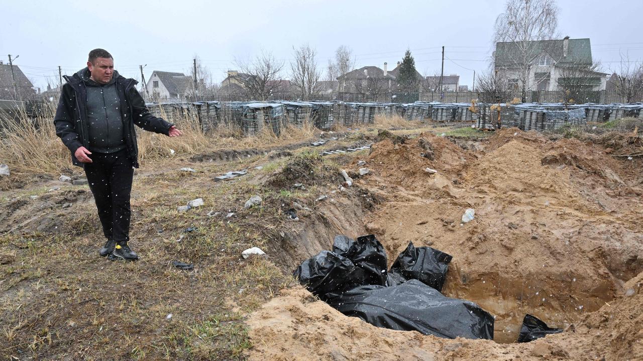 A man gestures at a mass grave in the town of Bucha. Picture: Sergei Supinsky/AFP