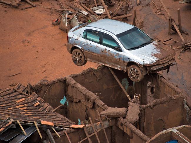 (FILES) This file photo taken on November 6, 2015 shows a general view where a dam burst in the village of Bento Rodrigues near Mariana in the southeastern Brazilian state of Minas Gerais. Shares in Anglo-Australian mining giant BHP Billiton plummeted seven percent in Sydney on May 4, 2016, after it revealed Brazil has filed a 43 billion USD lawsuit against it and co-owner Vale over the Samarco mine disaster. A dam at the mine they co-own broke on November 5 last year, spewing a deadly wall of mud and water that swamped a village, killed at least 17 and polluted a huge swath of river basin. / AFP PHOTO / CHRISTOPHE SIMON