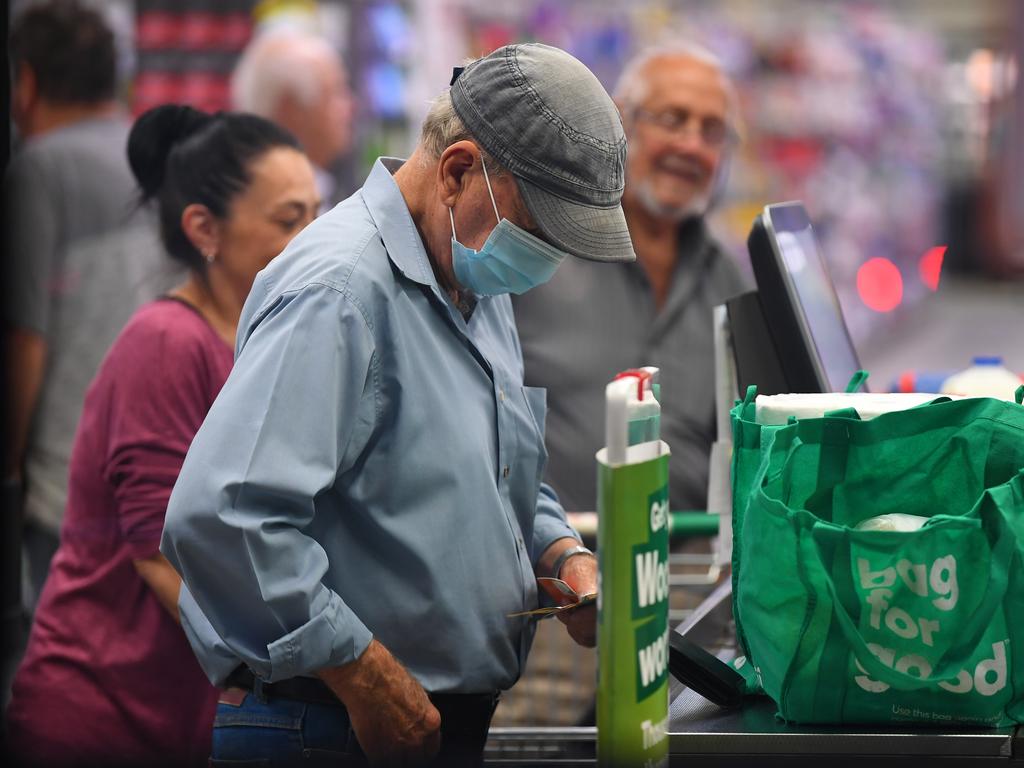 A man wears a face mask as a preventative measure against coronavirus at a checkout in a Woolworths supermarket in the Melbourne suburb of Coburg. Picture: James Ross/AAP