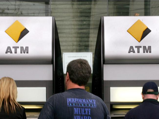 Customers use automatic teller machines (ATM) outside a branch of Commonwealth Bank of Australia (CBA) in Melbourne, 11 Aug 2004, while a display screen shows CBA shares are up after the bank posted a 28 percent rise in net annual profit.  AFP picWilliam/West logo logos ATMs