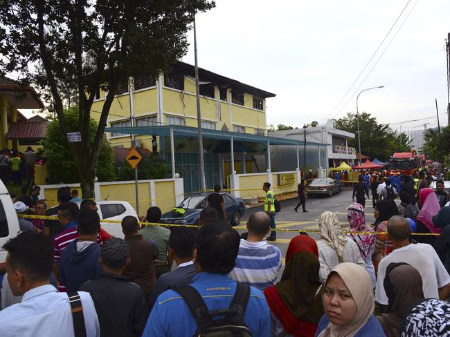 People gather outside an Islamic religious school which was cordoned off. Picture: AP
