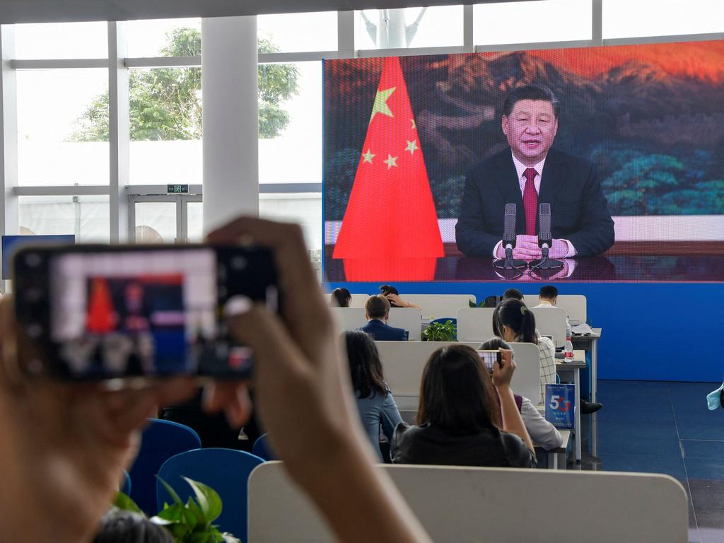 Journalists watch a screen showing China's President Xi Jinping. Picture: AFP