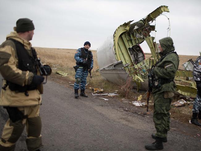 Pro-Russian gunmen guard as Dutch investigators (unseen) arrive near parts of the Malaysia Airlines Flight MH17 at the crash site. Picture: AFP