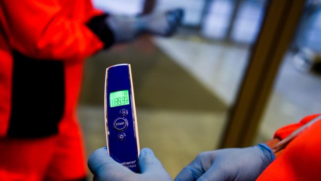 A health worker holds a temperature metre before passengers’ arrival from Milan Bergamo to Krakow International Airport on February 26 in Krakow, Poland. Picture: Omar Marques/Getty