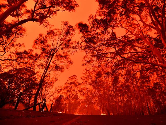 The afternoon sky glows red from bushfires in the area around the town of Nowra in the Australian state of New South Wales on December 31, 2019. - Thousands of holidaymakers and locals were forced to flee to beaches in fire-ravaged southeast Australia on December 31, as blazes ripped through popular tourist areas leaving no escape by land. Picture: Saeed Khan/AFP