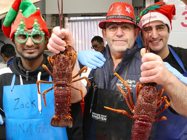 MELBOURNE, AUSTRALIA - NewsWire Photos, DECEMBER 24, 2023. Last minute food shopping at Victoria Market in Melbourne ahead of Christmas day.Zachariah Tanasegaran, Michael and Philip Azzardi with some lobsters. Picture: NCA NewsWire/ David Crosling